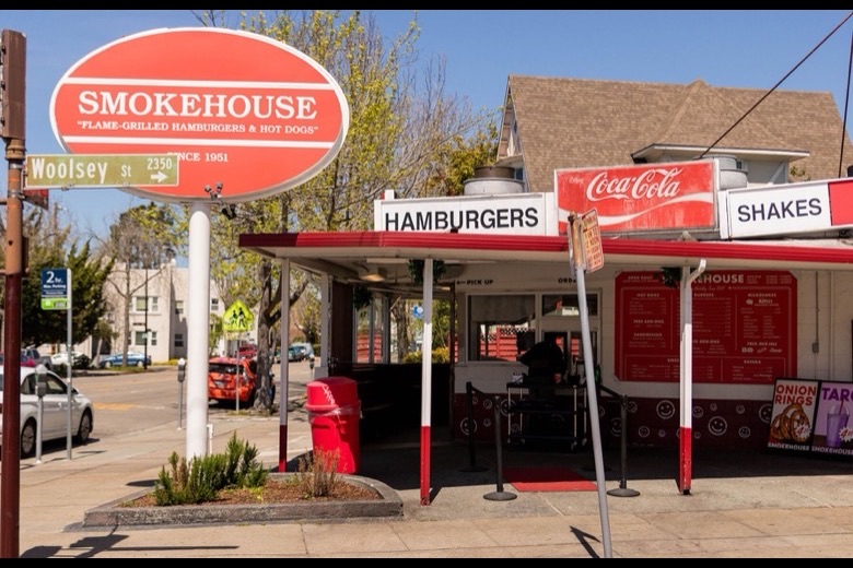 Smokehouse stand with its hamburgers and shakes signs at the corner of Woolsey Street